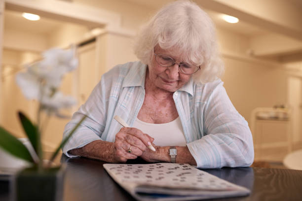 istock Senior woman concentrating on solving her crossword puzzle 1183007940