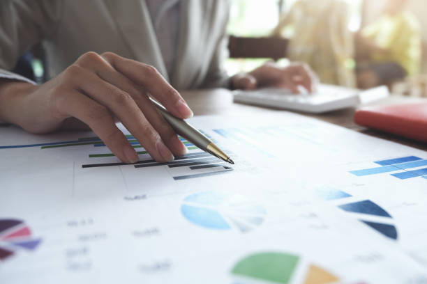 istock Business accounting concept, Business man pen pointing chart and using calculator to calculating budget and loan paper in office. 1183008035