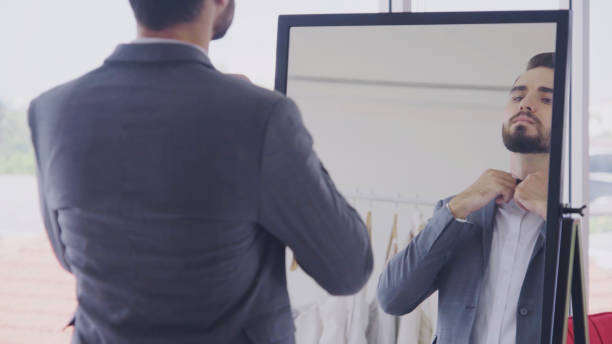 istock Man in formal suit getting dressed in dressing room for work or wedding. 1183011642