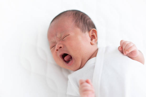 istock Crying baby on crib 1183011923