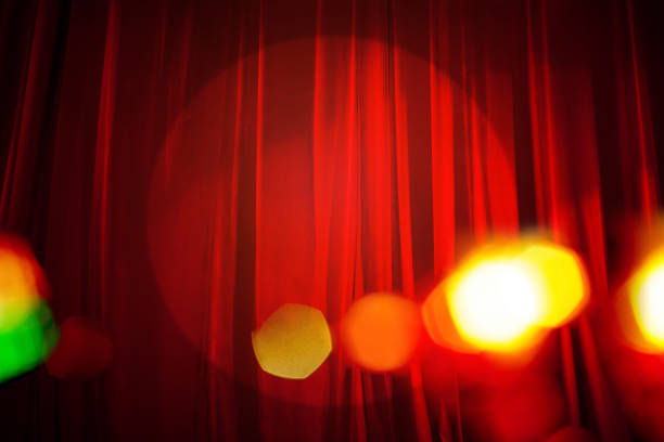 istock Red Curtain on Stage with Defocused Lights Background 1183020704