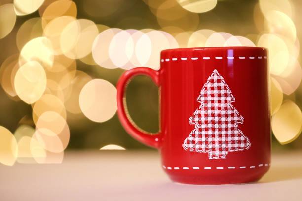 istock Christmas time.Mulled wine. Christmas tea in a red mug with a Christmas tree on the table on blurred Shining bokeh background.Winter drinks.New Year and Christmas holiday background 1183025655