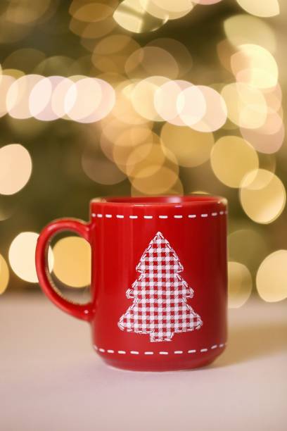 istock Christmas time.Mulled wine. Christmas tea in a red mug with a Christmas tree on the table on blurred Shining bokeh background.Winter drinks. 1183025656