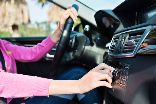 mujer controlar el volumen de radio en el coche - car dashboard air conditioner driving fotografías e imágenes de stock