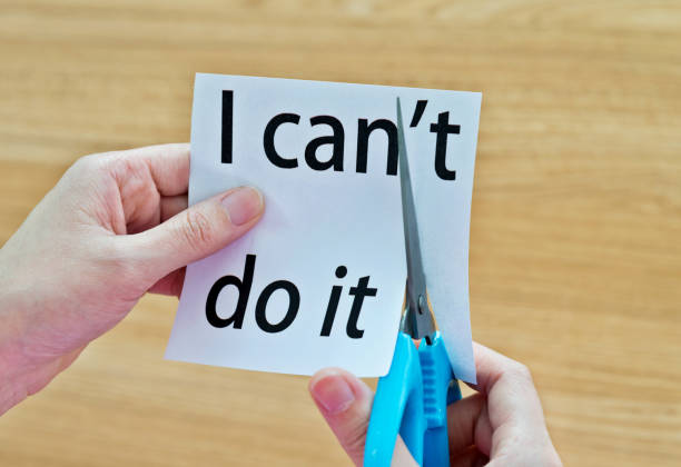 istock Human hand cutting word on paper can't become i can 1183031575
