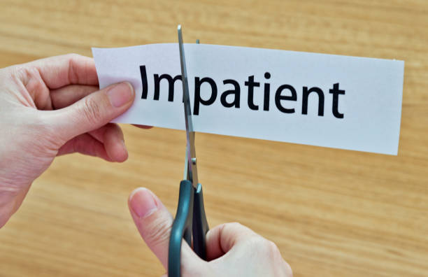 istock Human hand cutting the impatient word 1183031599