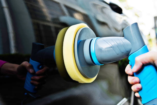 istock Woman hand using hand held car polishing machine 1183032682