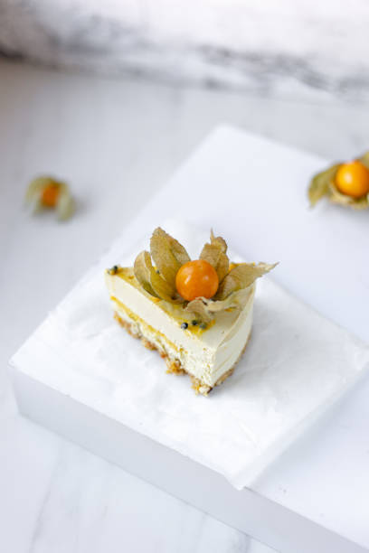 istock Passionfruit vegan cheesecake with Physalis on marble background with copy space 1183037473