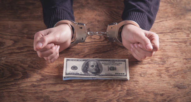 istock Hands in handcuffs holding dollar banknotes. Corruption 1183038675