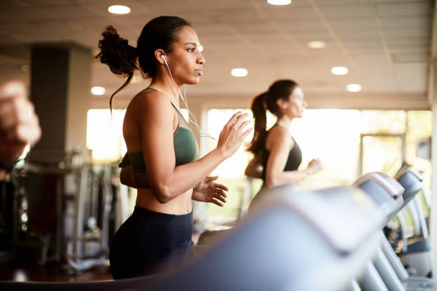 러닝머신에서 운동하는 젊은 여성 - treadmill 뉴스 사진 이미지