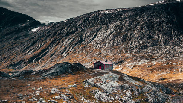istock Red house by the mountain 1183040135
