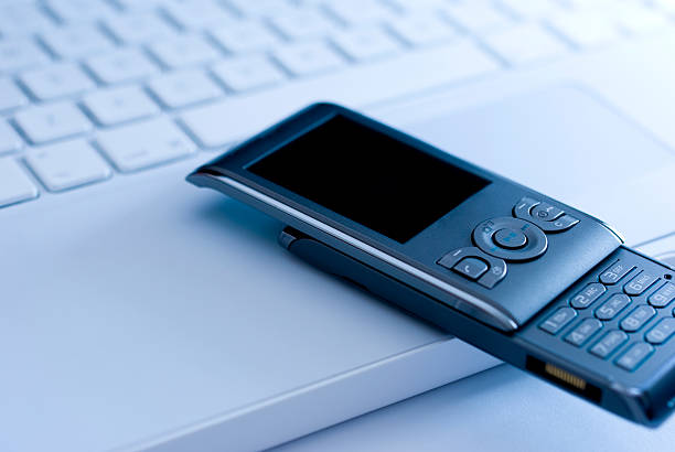 istock Mobile phone on white laptop keyboard 118304203