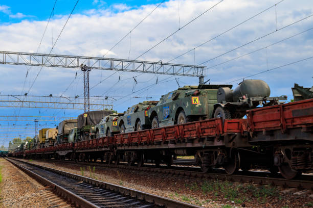 istock Cargo train carrying military vehicles on railway flat wagons 1183043396
