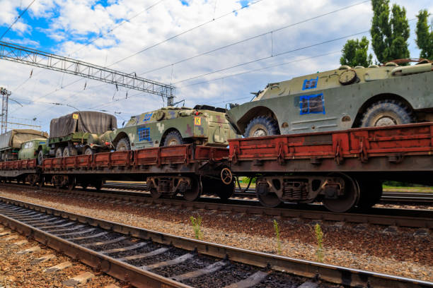 istock Cargo train carrying military vehicles on railway flat wagons 1183043399