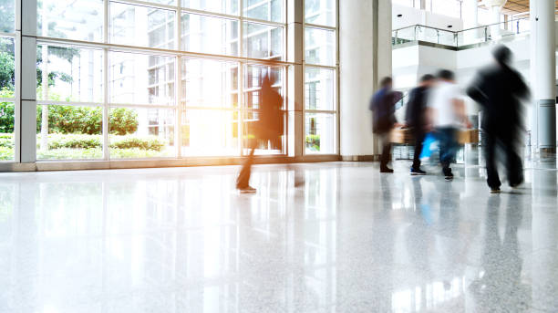 istock Motion blurred people walking in modern office 1183044528
