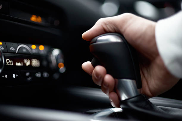 man switching gear, holding handle of the modern car, close-up view man switching gear, holding handle of the modern car, close-up view. selective focus gearshift photos stock pictures, royalty-free photos & images