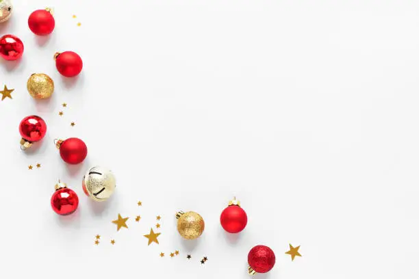Christmas Composition with golden and red festive balls and stars, isolated on white background,  copy space. Christmas creative flat lay, concept with festive ornaments.