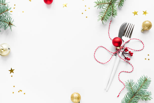 Christmas Table Setting Christmas Table Setting with fir branch and red ornaments on white, flat lay, copy space. Christmas dinner, party design, concept - table setting with festive decoration. restaurant table layout stock pictures, royalty-free photos & images