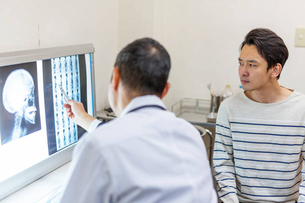istock Asian Doctor Examining an X-Ray With a Patient 1183048245
