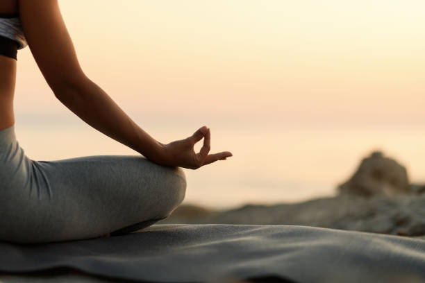 istock Close-up of woman meditating at sunset. 1183048310