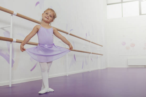 adorable pequeña bailarina haciendo ejercicio en la escuela de baile - ballet dress studio shot costume fotografías e imágenes de stock