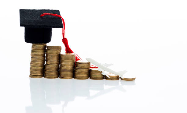 istock Graduation hat and plane toy on coins 1183050803