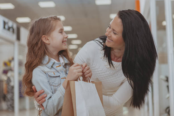 beautiful woman shopping at the mall with her cute little daughter - boutique shopping retail mother imagens e fotografias de stock