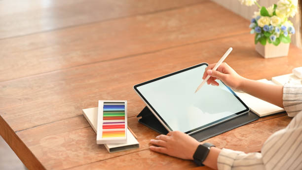 istock Close up young creative woman working with tablet and stylus pen. 1183051297