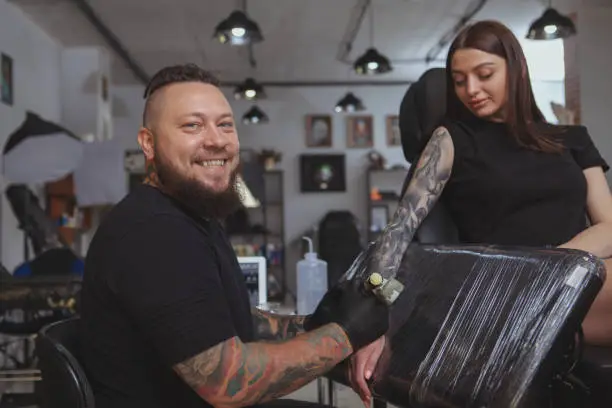 Photo of Professional tattoo artist working at his studio