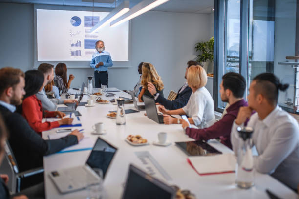 istock Executive Team in Board Room Listening to Presentation 1183053275