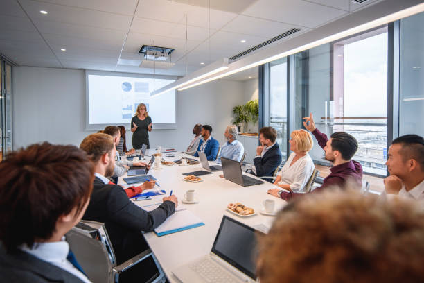 istock Young Businessman With Raised Hand at Executive Meeting 1183053294