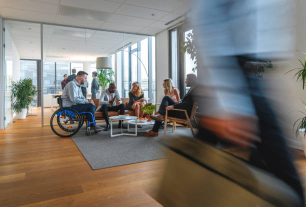 istock Diverse Group of Colleagues Conversing in Busy Office Lobby 1183053340