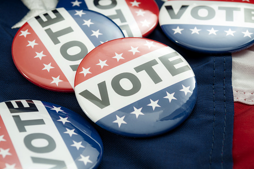 Encuesta demócrata vs republicana, decisión democrática y idea conceptual de votación primaria con insignias de botón de campaña electoral de votación y los estados unidos de la bandera americana photo