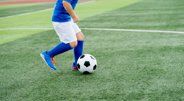istock Young boy running after a soccer ball 1183053958