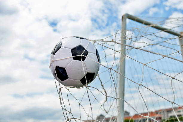 istock Soccer ball hitting the net 1183055280