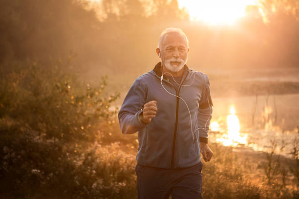 istock Active Senior man jogging by lake in morning time 1183055398