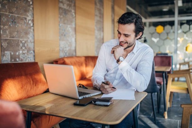 istock Handsome gentleman sitting in cafe and working 1183057015