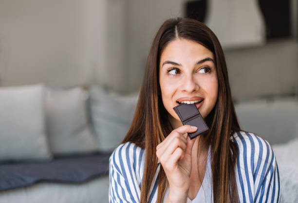 istock woman choosing between chocolate and apple 1183058147
