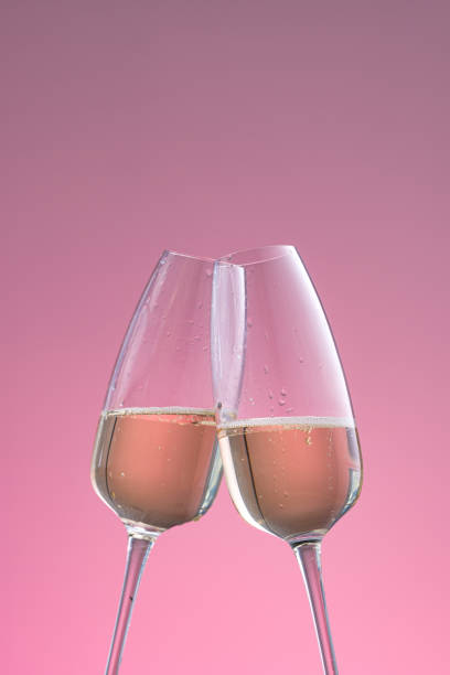 istock two glasses of sparkling wine on a pink background 1183060247