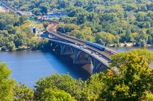 Aerial view of Metro bridge with subway train passing and the Dnieper river in Kiev, Ukraine. Kyiv cityscape