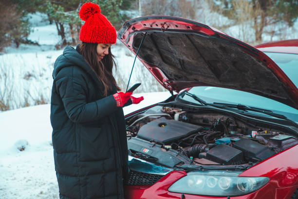 vrouw belt om hulp met kapotte auto bij de winter snelweg gestopt bij de weg - vehicle breakdown stockfoto's en -beelden