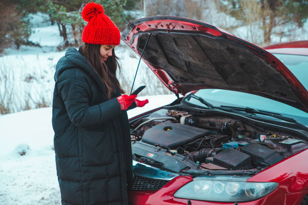 istock woman calling for help with broken down car at winter highway stopped at roadside 1183061463
