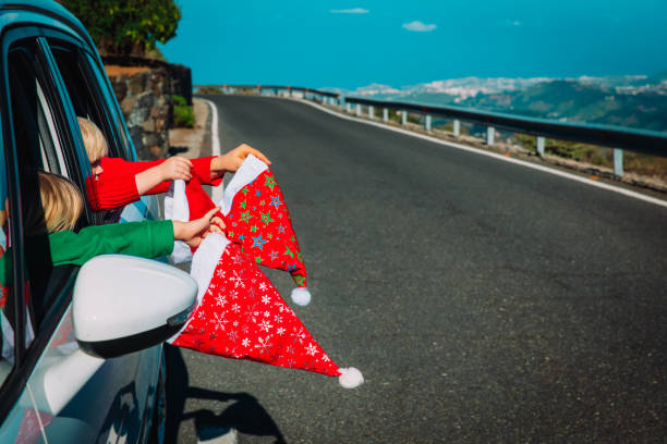 christmas family travel concept, family with santa hats in car on road stock photo