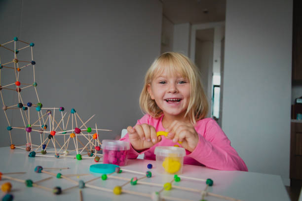 istock cute girl making geometric shapes from clay, engineering and STEM 1183063306
