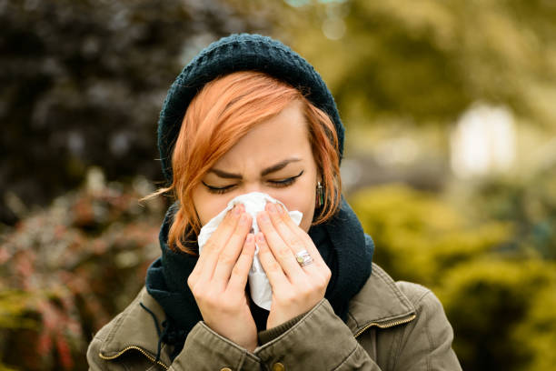 istock Young woman blowing a nose 1183063906