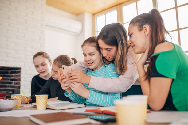 istock Woman teacher and girls students using phone on class 1183066644