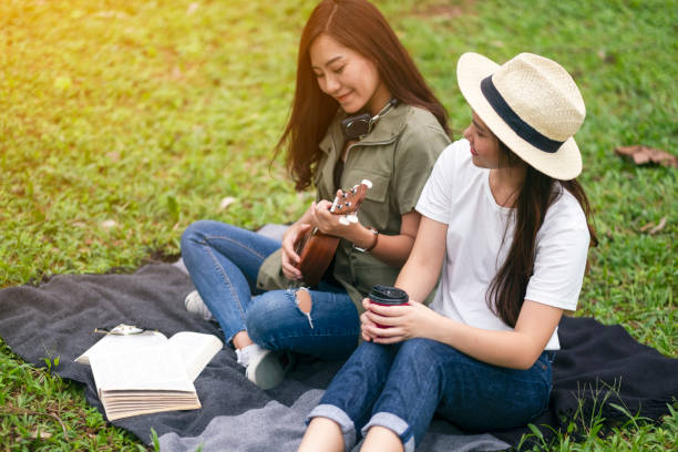 istock Two women playing ukulele while sitting together 1183068327