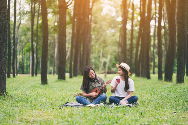 istock Two women playing ukulele while sitting together 1183068428