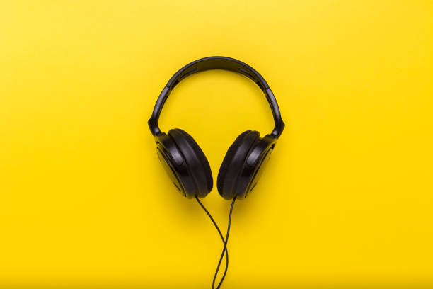 istock Black headphones on a yellow background. Flat lay, top view 1183069316