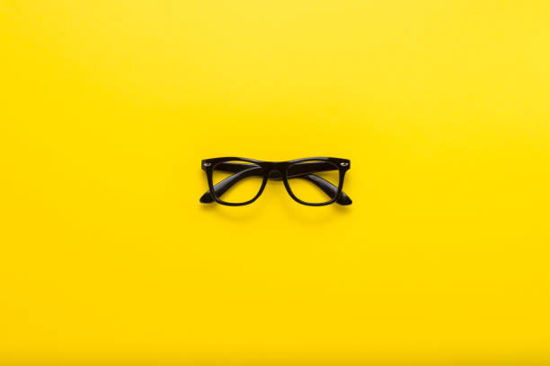 istock Black glasses on a yellow background. Flat lay, top view 1183069362